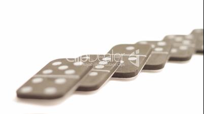 Falling dominoes with rack focus on white