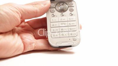Hand holding cel phone and tapping buttons isolated on white