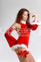 Female Santa in sexual red dress on light background