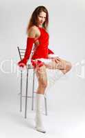 Female Santa in sexual red dress on light background