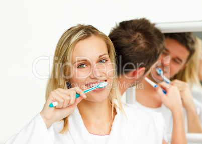 couple cleaning their teeth