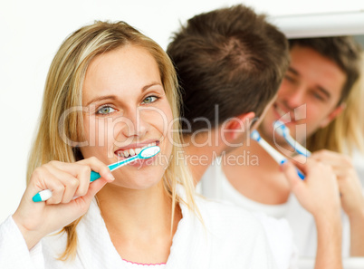 Couple cleaning their teeth
