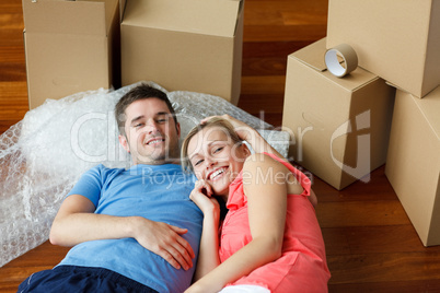 couple lying on floor with a lot of boxes