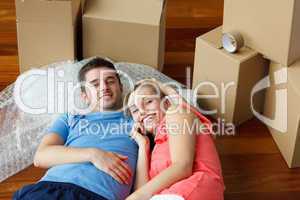 couple lying on floor with a lot of boxes