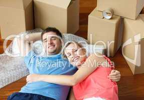 couple lying on floor with a lot of boxes