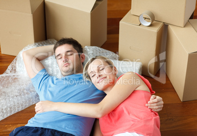 couple lying on floor with a lot of boxes