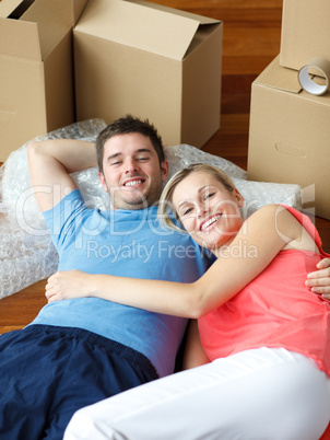 couple lying on floor with a lot of boxes