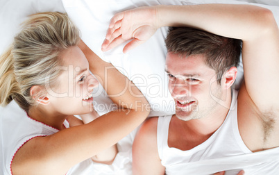 Couple relaxing and smiling in bed