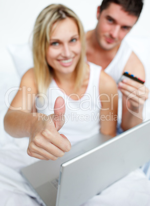 Couple in bed with thumb up