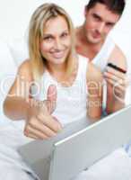 Couple in bed with thumb up