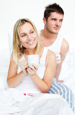 Couple drinking a cup of tea in bed