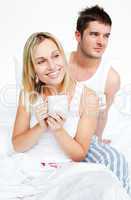 Couple drinking a cup of tea in bed