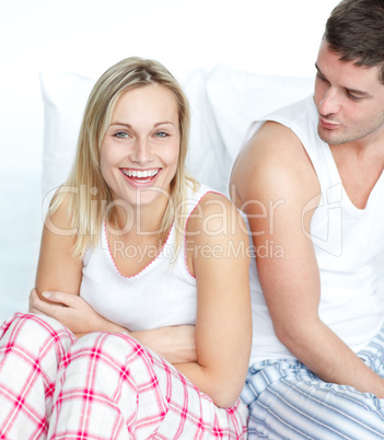 Smiling woman having fun with a man in bed
