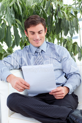 businessman reading papers on a sofa