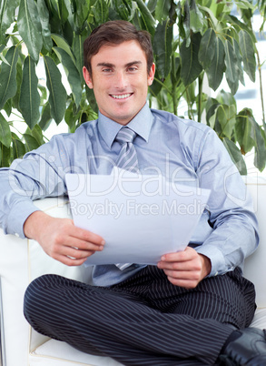 businessman reading papers on a sofa