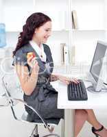 Businesswoman eating an apple in office