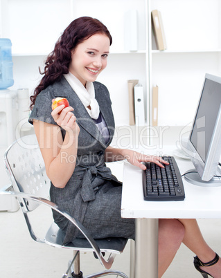 Businesswoman holding an apple in office