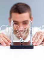 Businessman looking at pendulum balls