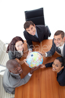 smiling team holding a globe