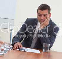 Attractive businessman bored in a meeting