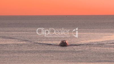 Fishing boat coming to port at sunset