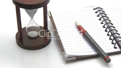 Hourglass pen and lined notebook