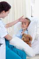 Female doctor checking child temperature