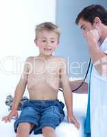 Doctor examinating a little boy with stethoscope