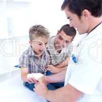 Doctor bandagins a child's arm who is yelling