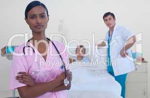 Serious attractive nurse with doctor and patient