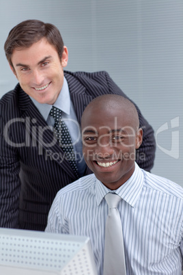 Smiling businessmen using a computer together