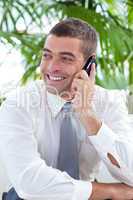 Businessman sitting on sofa and talking on phone