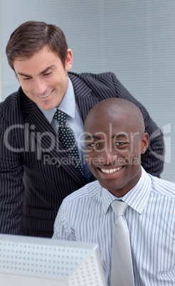 Smiling businesmen working together with a computer