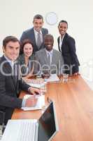 Five business people in a meeting smiling at the camera