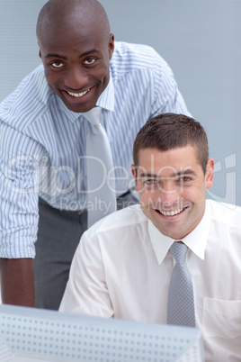 Two businessmen using a computer in office