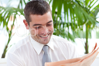 Businessman reading a newspaper in workplace