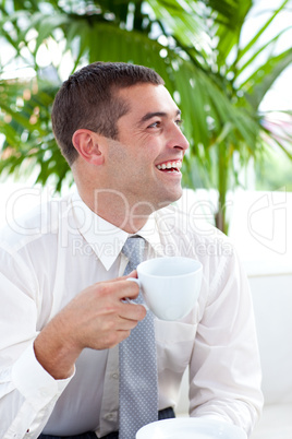 Happy businessman relaxing with a cup of coffee