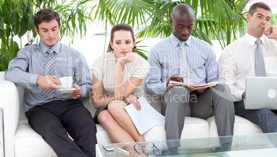 Bored business people sitting on a sofa waiting for an interview