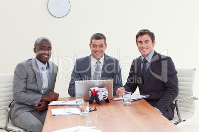 Three businessmen in a meeting smiling