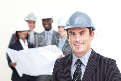 Attractive male architect with his team in the background