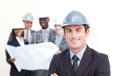 Confident male architect with his team in the background