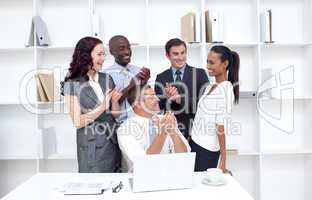 Business team applauding a collegue in office