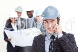 Confident male architect with his team in the background