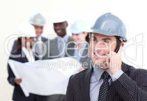 Confident male architect with his team in the background