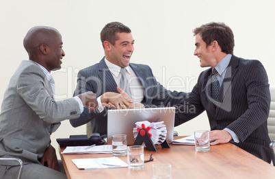 Three businessmen in a meeting celebrating a success