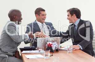 Three businessmen in a meeting celebrating a success