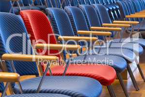 Roter Sitz unter vielen blauen