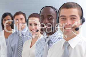 Afro-American businessman smiling and standing in a call center