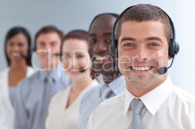 Smiling businessman standing  in a call center in a line