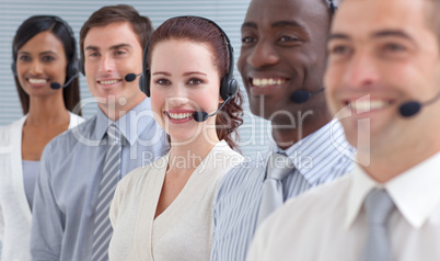 Smiling businesswoman working in a call center in a line
